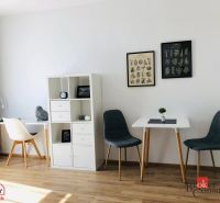 Innenraum einer Einzimmerwohnung mit Holzboden und stilvollen Stühlen.