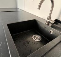 Küchenzeile mit Spüle und Armatur in einer Einzimmerwohnung.
