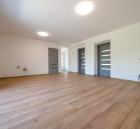 Wohnzimmer in einem Einfamilienhaus mit Holzboden und weißen Wänden.
