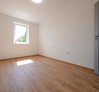 Ein Zimmer mit Holzboden in einem Einfamilienhaus ohne Möbel.