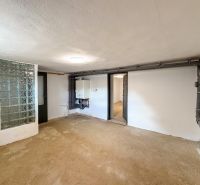 Ein Raum in einem Einfamilienhaus mit einer Glasbausteinwand und Installationen an der Wand.