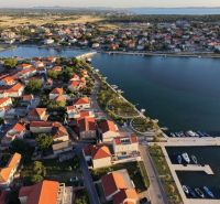 Luftaufnahme des Küstengebiets der Stadt Nin mit den Dächern von Villen und dem Hafen.