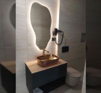 Ein Badezimmer mit modernem Licht, Spiegel und Designer-Waschbecken in einer Villa.