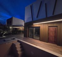 Eine Villa in Ninu mit Treppen und einem Holzboden-Dekor in der Dämmerung.