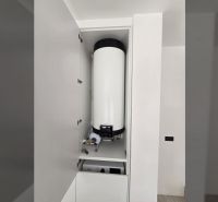 Boiler im Schrank in der Villa, weiße Wand, einfaches Interieur.