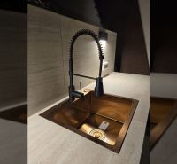 Küchenarmatur mit flexiblem Wasserhahn und goldenem Küchenspülbecken in einer Villa.