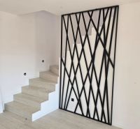 Treppe mit schwarzem dekorativem Geländer und Boden mit Holzdekor in der Villa.