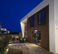Eine Villa in der Straße Nin in Nin mit moderner Architektur und einer Terrasse am Abend.