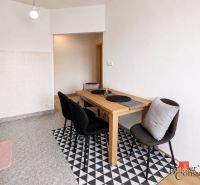 Essbereich in einer 2-Zimmer-Wohnung mit schwarzen Stühlen und einem Holztisch.