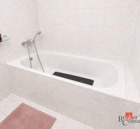 Badezimmer mit einer mit weißen Fliesen verkleideten Badewanne in einer 2-Zimmer-Wohnung.