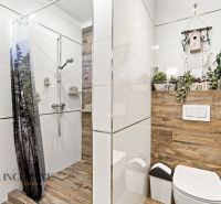 Ein Badezimmer in einem Einfamilienhaus mit einem Boden in Holzoptik und einer Duschkabine mit Vorhang.