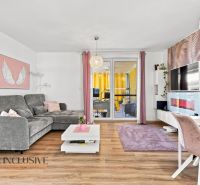 Wohnzimmer in einem Einfamilienhaus mit einem bequemen Sofa und einem Boden in Holzoptik.