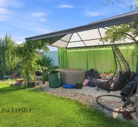 Der Garten eines Einfamilienhauses in Oľdza mit einer Pergola, Vorhängen und einer Schaukel zur Entspannung.