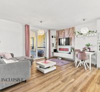 Wohnzimmer mit bequemer Couch, Fernseher, Esstisch und Holzboden in einem Einfamilienhaus.