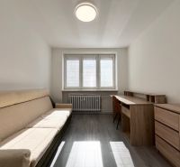 Ein Zimmer in einer 3-Zimmer-Wohnung mit einem Sofa, einem Schreibtisch und einem Holzboden.