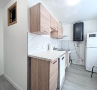 Küche in einer 3-Zimmer-Wohnung mit Holzboden und weißen Geräten.