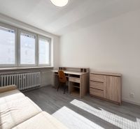 Wohnzimmer mit Schreibtisch und Sofa, Holzboden in einer 3-Zimmer-Wohnung.
