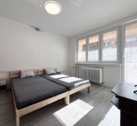 Helles Schlafzimmer mit Bett, Fernseher und Holzboden in einer 3-Zimmer-Wohnung.