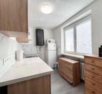 Küche in einer 3-Zimmer-Wohnung mit Fliesen und Holzschränken.