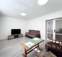 Wohnzimmer in einer 3-Zimmer-Wohnung mit Holzboden und Einrichtung.