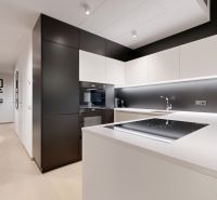 Schwarz-weiße Küche mit Holzboden in einer 3-Zimmer-Wohnung, modernes Design.