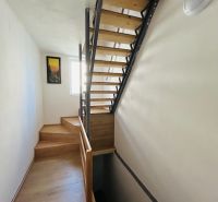 Eine Treppe mit Holzdekor in einem Einfamilienhaus mit hellem Interieur und einem Bild an der Wand.