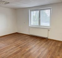 Ein leerer Raum mit Holzboden, einem Fenster und weißen Wänden in einem Einfamilienhaus.