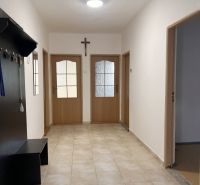 Flur in einem Einfamilienhaus mit Fliesen, Holztüren und Garderobe.