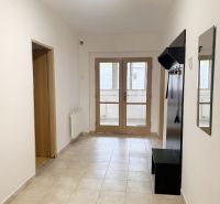 Flur mit Garderobe und Fliesen in einem Einfamilienhaus, die Tür führt auf die verglaste Terrasse.