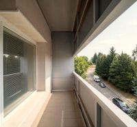 Der Balkon einer 2-Zimmer-Wohnung in Bánovce nad Bebravou mit Blick auf die Straße und Bäume.