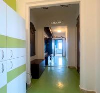 Der Flur in der 2-Zimmer-Wohnung mit grünem Boden und Möbeln mit weiß-grünen Elementen.