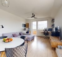 Wohnzimmer mit Sofa, Esstisch und Holzboden in einer 3-Zimmer-Wohnung.