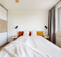 Schlafzimmer in einer 3-Zimmer-Wohnung mit einem großen Bett, einem Einbauschrank und einem Fenster.