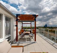 Eine Terrasse mit Blick auf die Stadt, mit einer Pergola und einer Außensitzgelegenheit in einer 3-Zimmer-Wohnung.