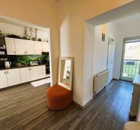 Innenraum mit Küchenzeile, Boden in Holzoptik und Balkontüren in einer 2-Zimmer-Wohnung.