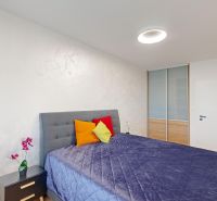 Schlafzimmer mit gepolstertem Bett, Kleiderschrank und Nachttisch, 2-Zimmer-Wohnung.