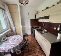 Küche in einer 2-Zimmer-Wohnung mit Holzboden und Esstisch.