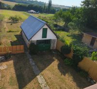 Garten und Gebäude bei einem Einfamilienhaus in Jelenci, umgeben von Feldern und Bäumen.