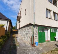 Ein Einfamilienhaus in Jelenec mit Steinverkleidung und grünen Türen.
