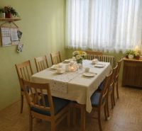 Esszimmer in einem Einfamilienhaus mit gedecktem Tisch und Boden in Holzoptik.