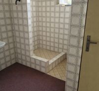 Badezimmer in einem Einfamilienhaus mit Retro-Fliesen und einer Duschkabine.
