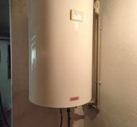 Ein Warmwasserspeicher an der Wand in einem Einfamilienhaus mit sehr einfachen Ventilen.