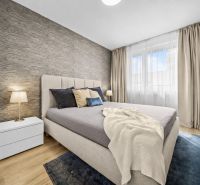Schlafzimmer mit Bett und Nachttisch, Boden mit Holzdekor in einer 2-Zimmer-Wohnung.