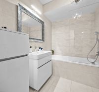 Badezimmer in einer 2-Zimmer-Wohnung mit Dusche und Badewanne, helle Fliesen.