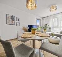 Innenraum einer 2-Zimmer-Wohnung mit Essbereich, Holzboden und elegantem Kronleuchter.