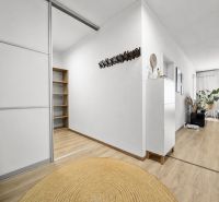 Innenraum einer 2-Zimmer-Wohnung mit Holzboden, Pflanzen und praktischen Möbeln.