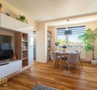 Wohnzimmer in einer 3-Zimmer-Wohnung mit Holzdekorboden und Essecke.