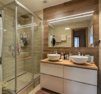 Badezimmer in einer 3-Zimmer-Wohnung mit Doppelwaschbecken, Duschkabine und Waschmaschine.