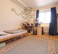 Kinderzimmer in einer Zweizimmerwohnung mit Bett, Tisch und Holzboden-Dekor.