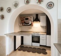 Eine Küche in einem Einfamilienhaus mit einem bogenförmigen Eingang, dekoriert mit Tellern und modernen Details.